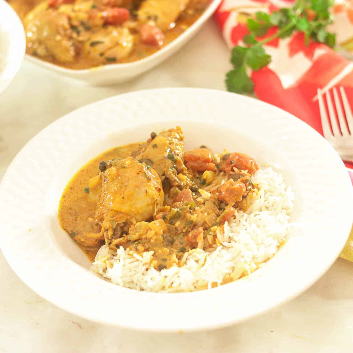 Bowl with Chicken Curry and Rice. Additional bowls with rice and curry chicken seperately in background.