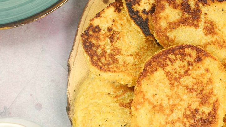 Cornmeal Pancakes on a plate with a cup of tea on the side