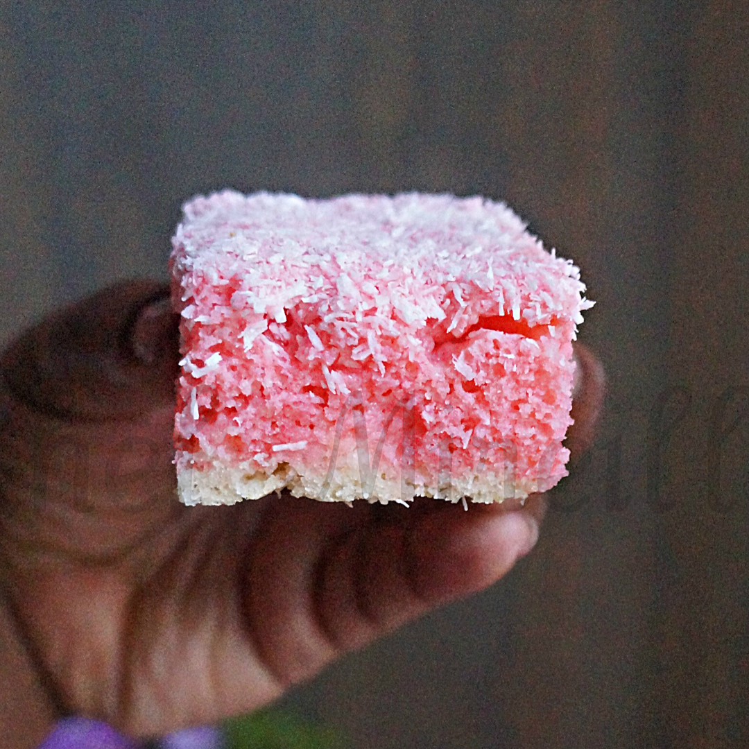 Strawberry Cake with coconut held in a hand - Strawberry Lamington 