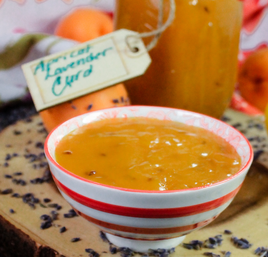 bowl of curd in a bowl with apricots and bottled jar with label in background