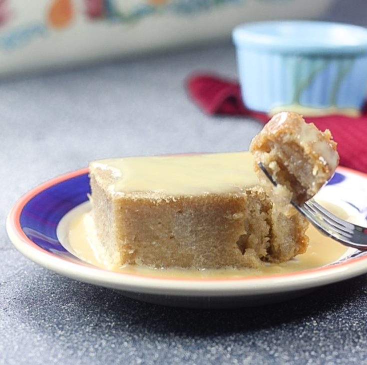 slice of cake on a plate with fork and condensed milk