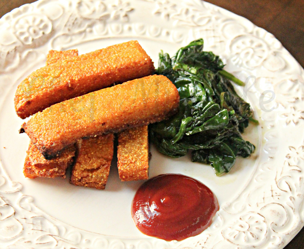 plate of polenta fries with ketchup and sauteed spinach