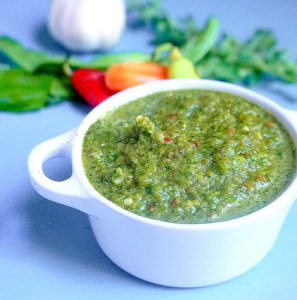 bowl of sofrito marinade with fresh vegetables in background