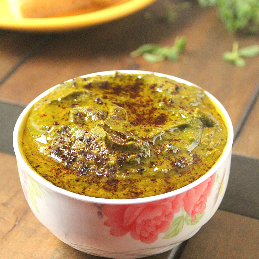 bowl of spinach hummus on a wooden table