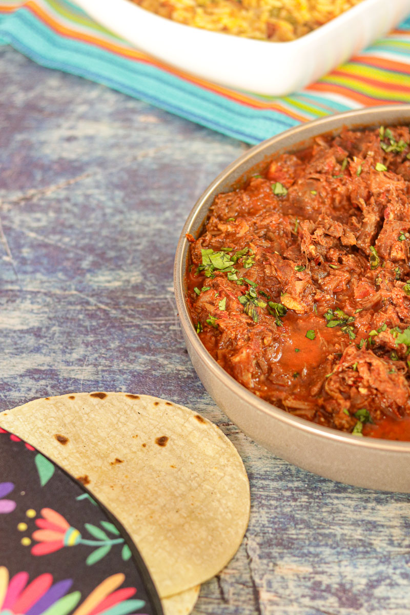 Mexican Goat Birria with Consome in a bowl with taco shells for Birria Tacos