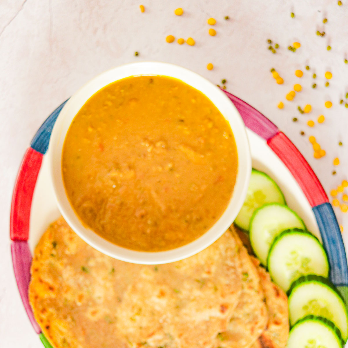 bowl of Panchmel Dal with roti and cucumbers
