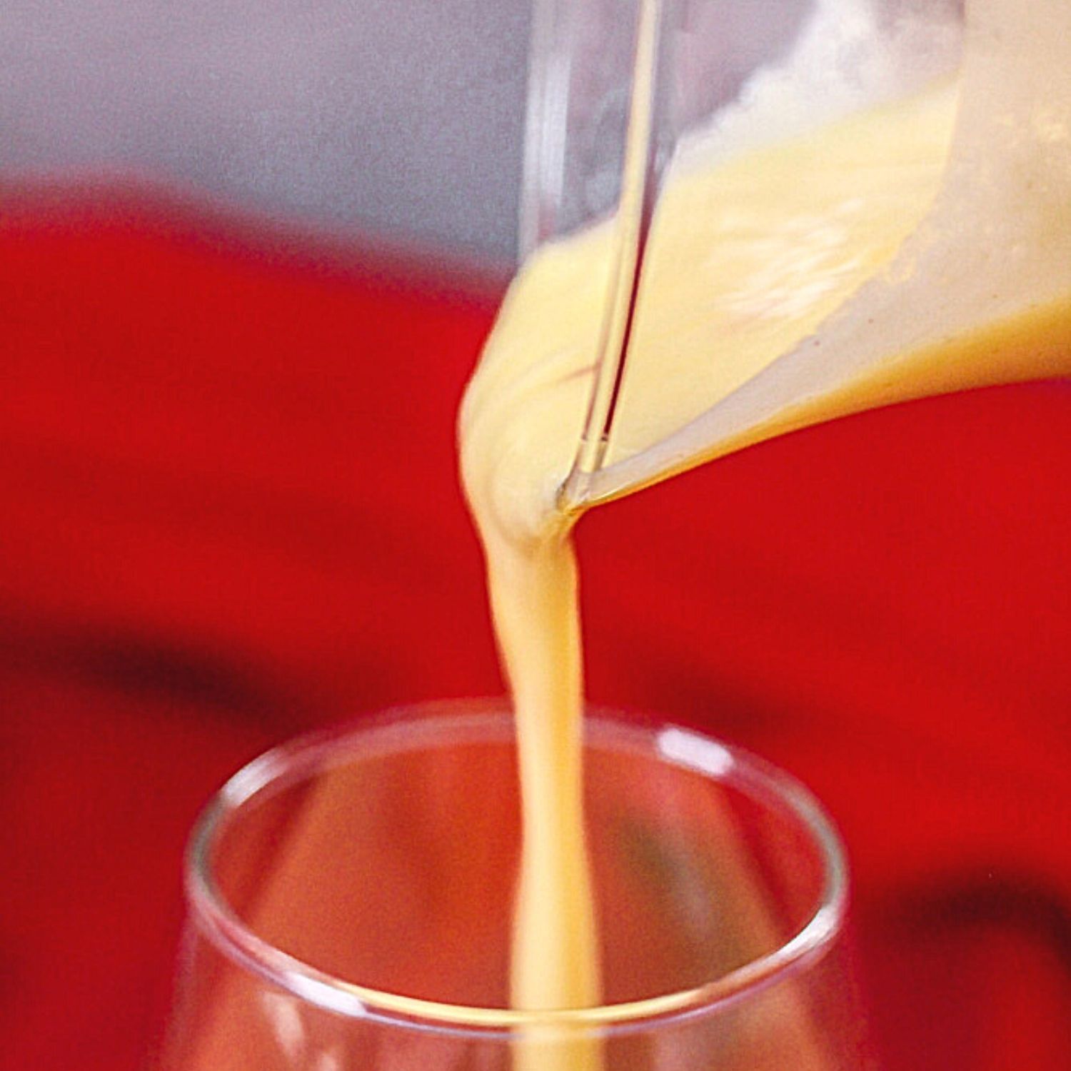 Creamy Mango Lassi pouring into a glass