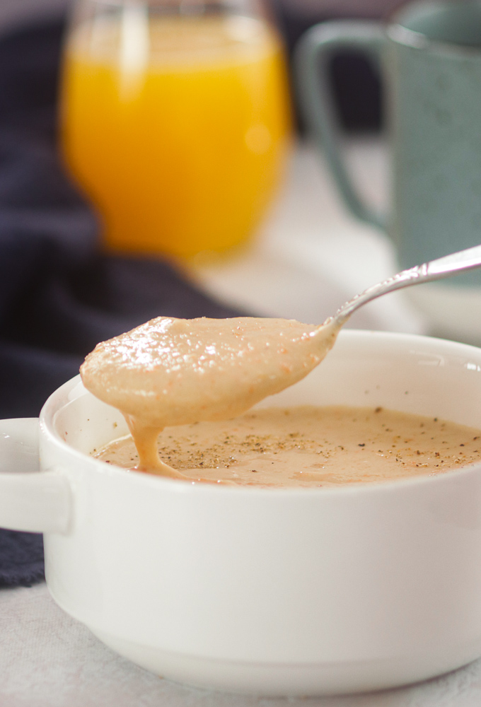 Bowl of Plantain Porridge with juice and coffee in the background.