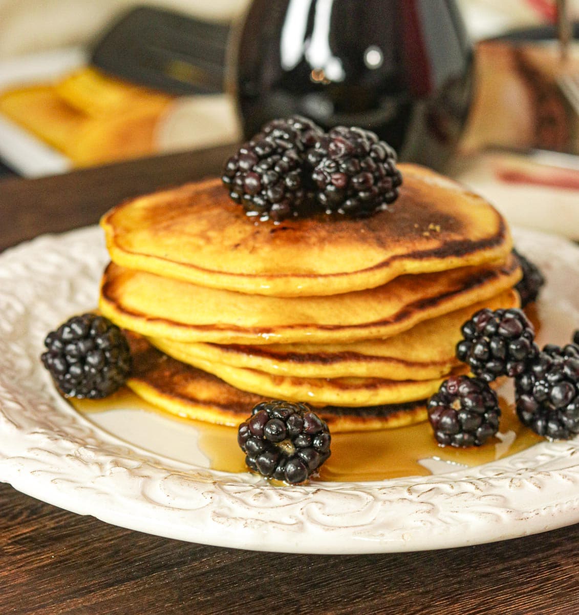 Pumpkin Pancakes on a plate with syrup and blackberries