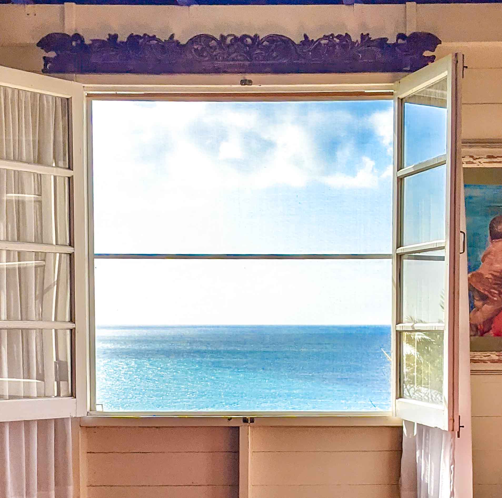 Window with view of beach sea and sky at Galley Bay Cottages #antigua #visitantigua #caribbeantravel