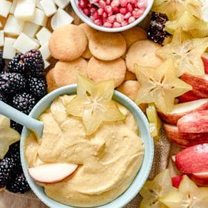 bowl of pumpkin dip with fresh fruit, cheese and cookies