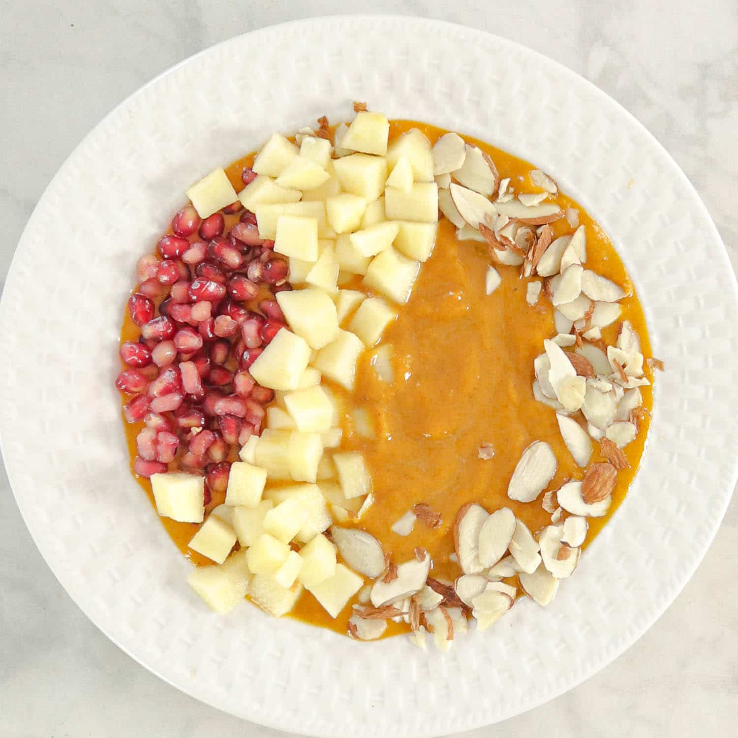 Pumpkin Smoothie in a bowl topped with fruits and nuts