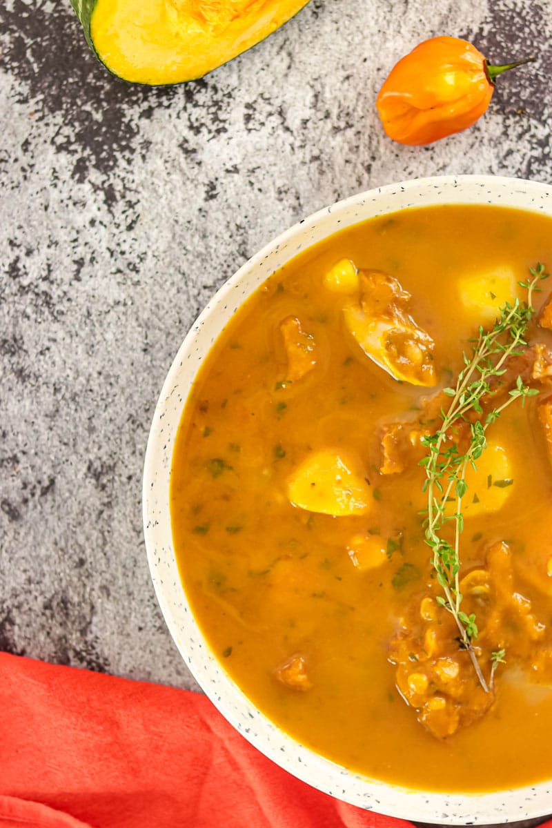 bowl of pumpkin soup garnished with fresh thyme