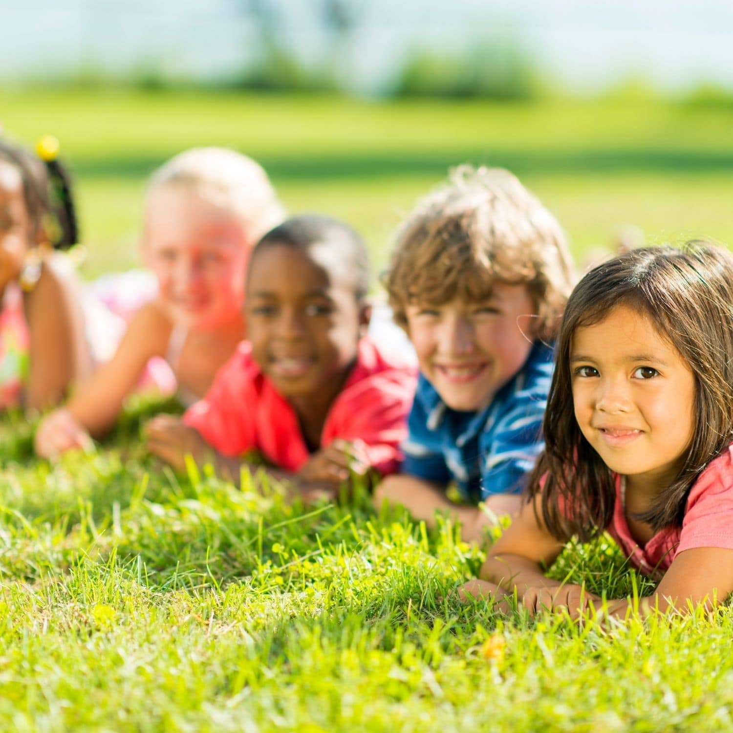 diverse kids laying on grass