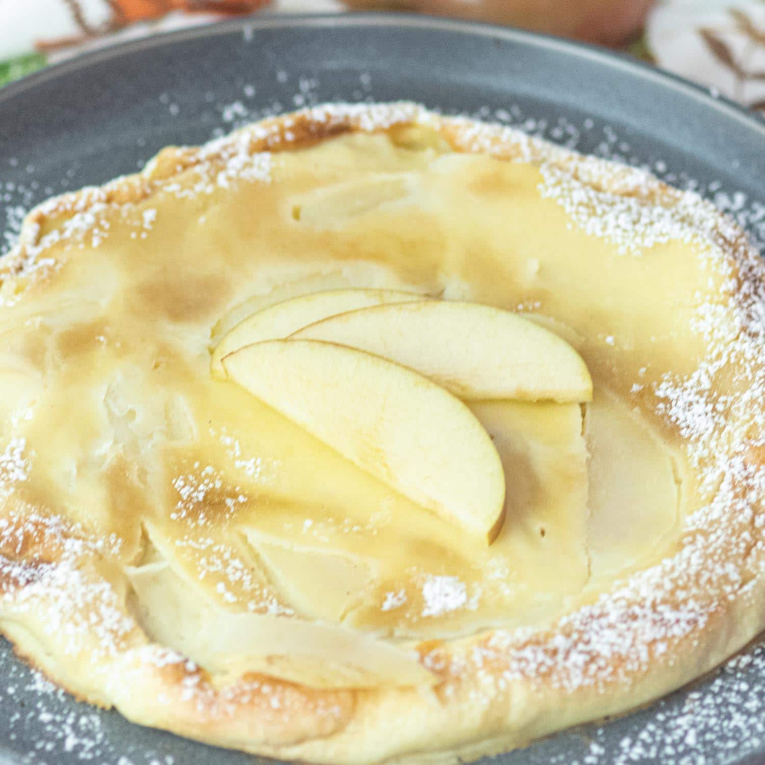 Apple Oven Pancake with fresh apples slices on top and powdered sugar