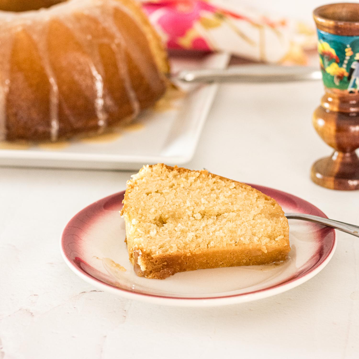 Haitian Cake Recipe on a plate with the Haitian Cake with Eggnog Glaze in the background