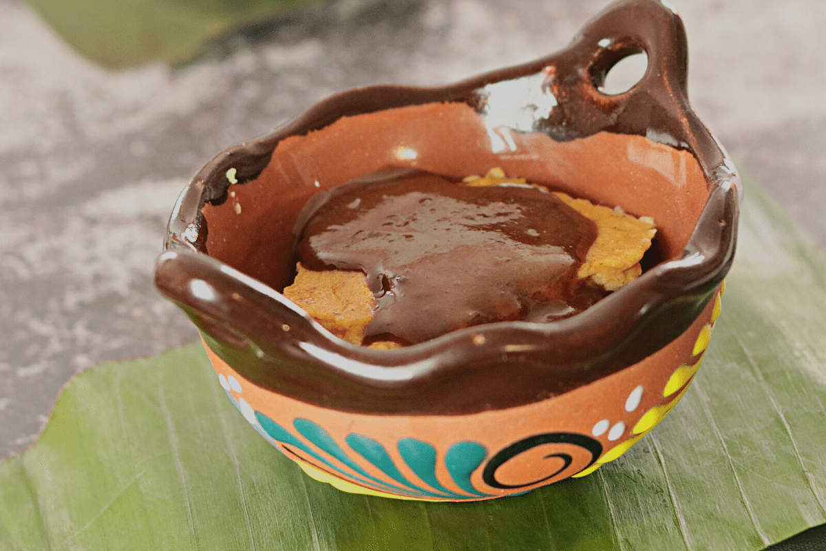 Custard with chocolate sauce in a Mexican bowl on a banana leaf