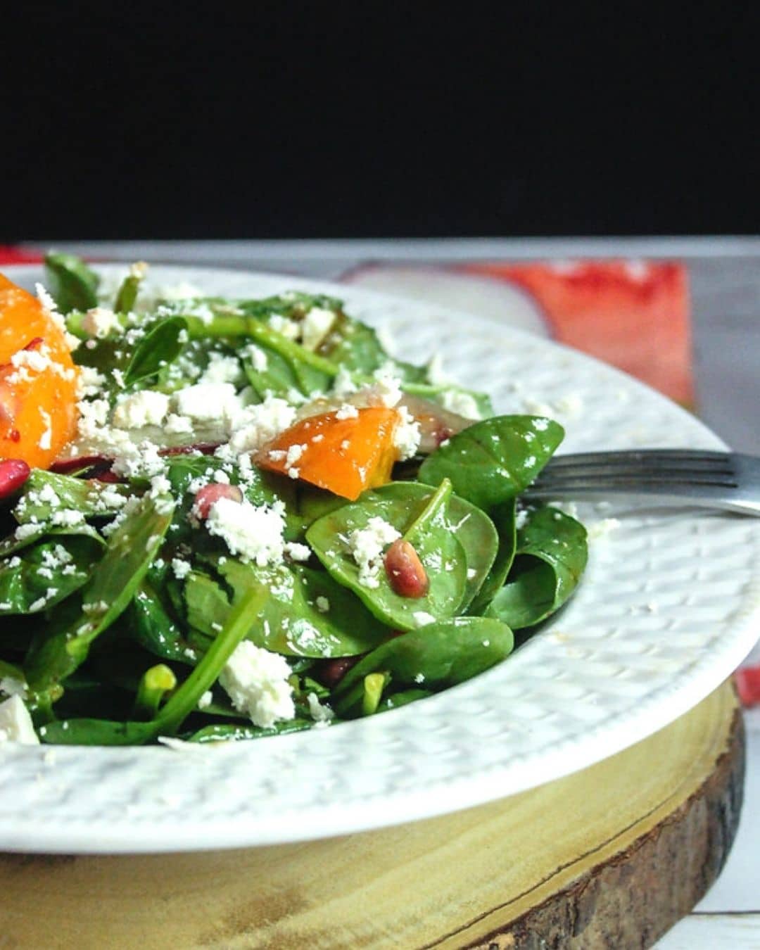 plate of Spinach Salad with Fresh apricots,pomegrante seeds and manouri cheese