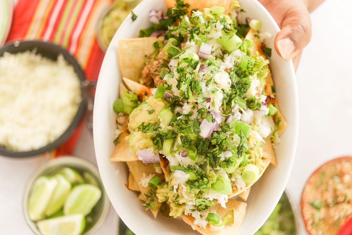 bowl of Loaded Nachos with lime in the background