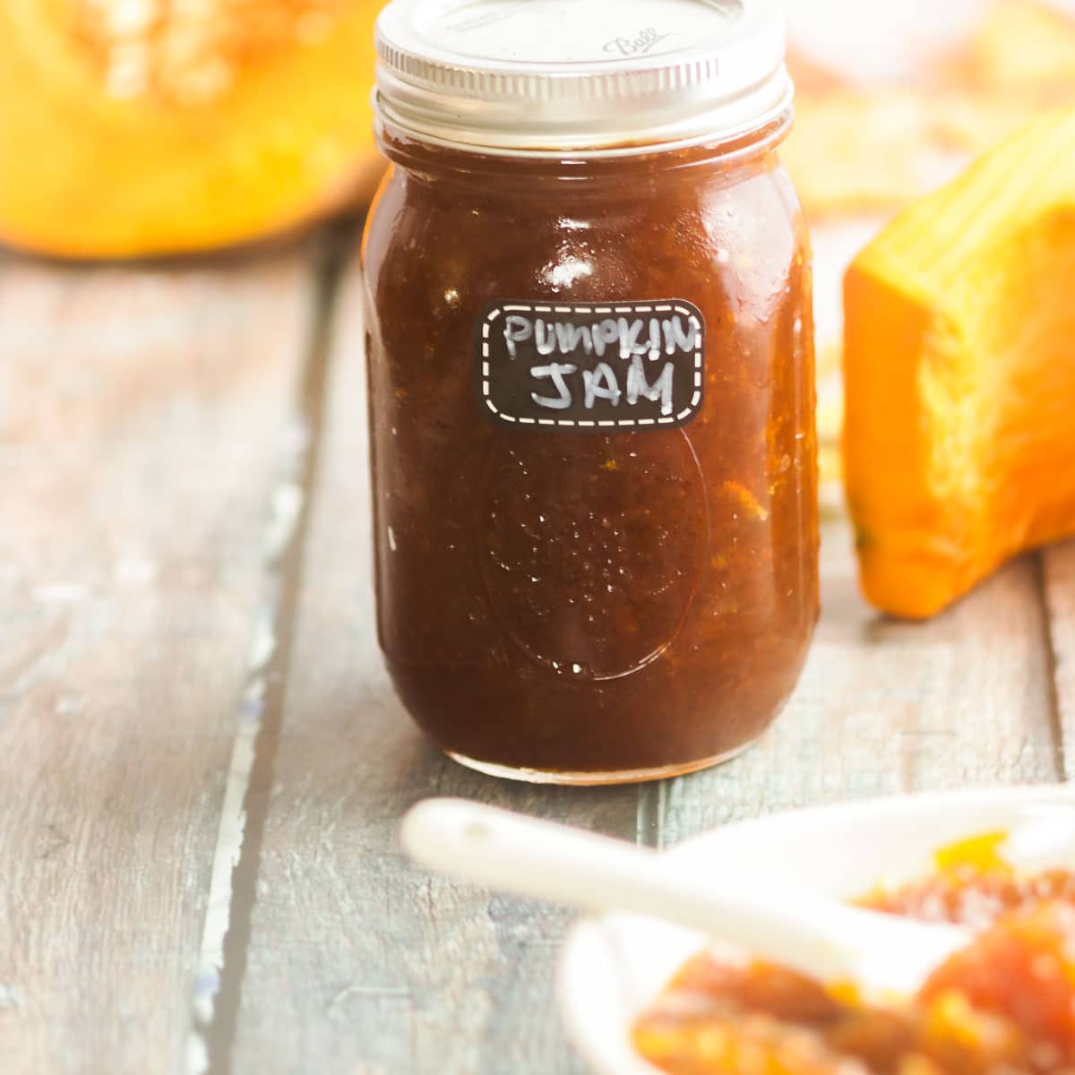 Jar of Pumpkin jam recipe with fresh pumpkin in background